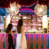 Two women walking in front of pink bar 