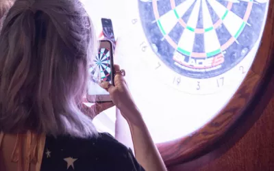 persons taking photo of electronic dart board