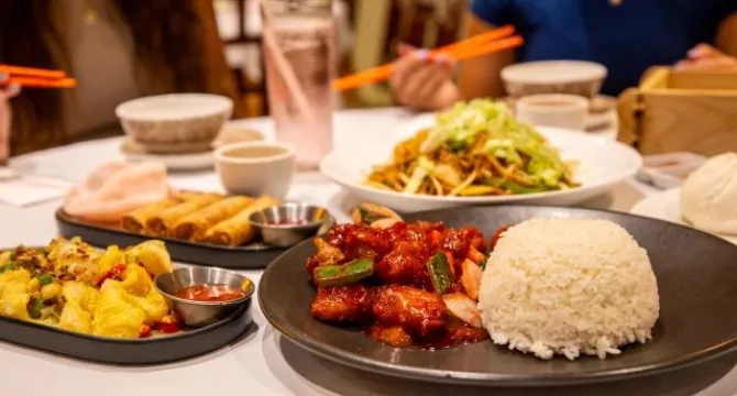 Plates of food including pork and rice, spring rolls and noodles