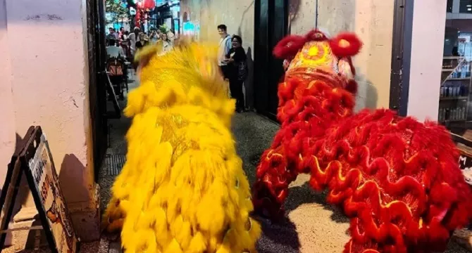 two chinese lion dance performers facing into Bakery lane
